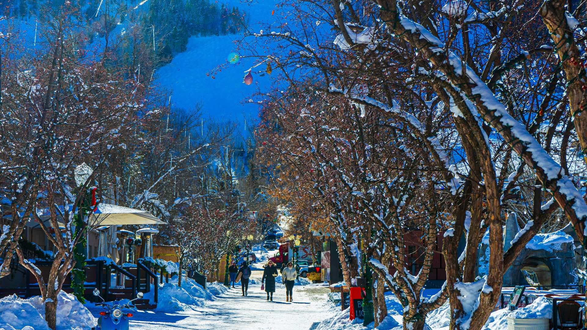 a snowy street with people walking down it