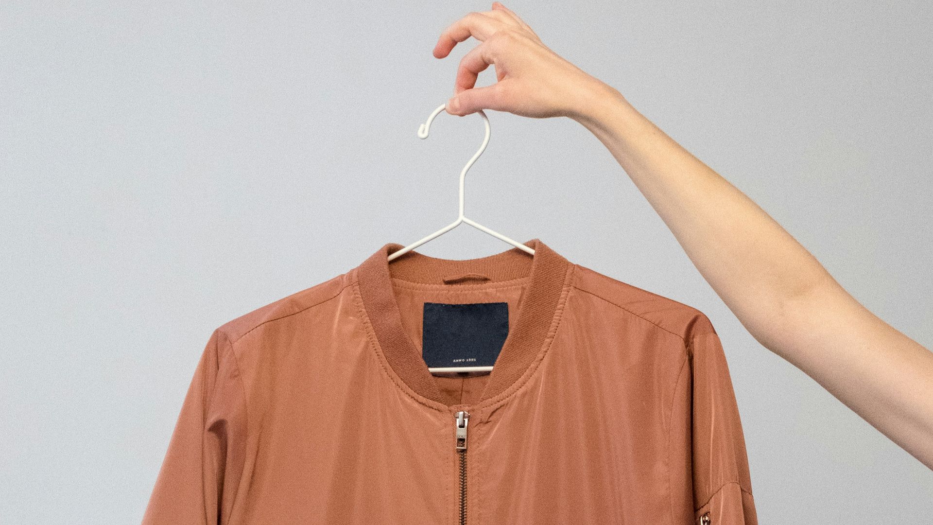 brown long sleeve shirt on white clothes hanger
