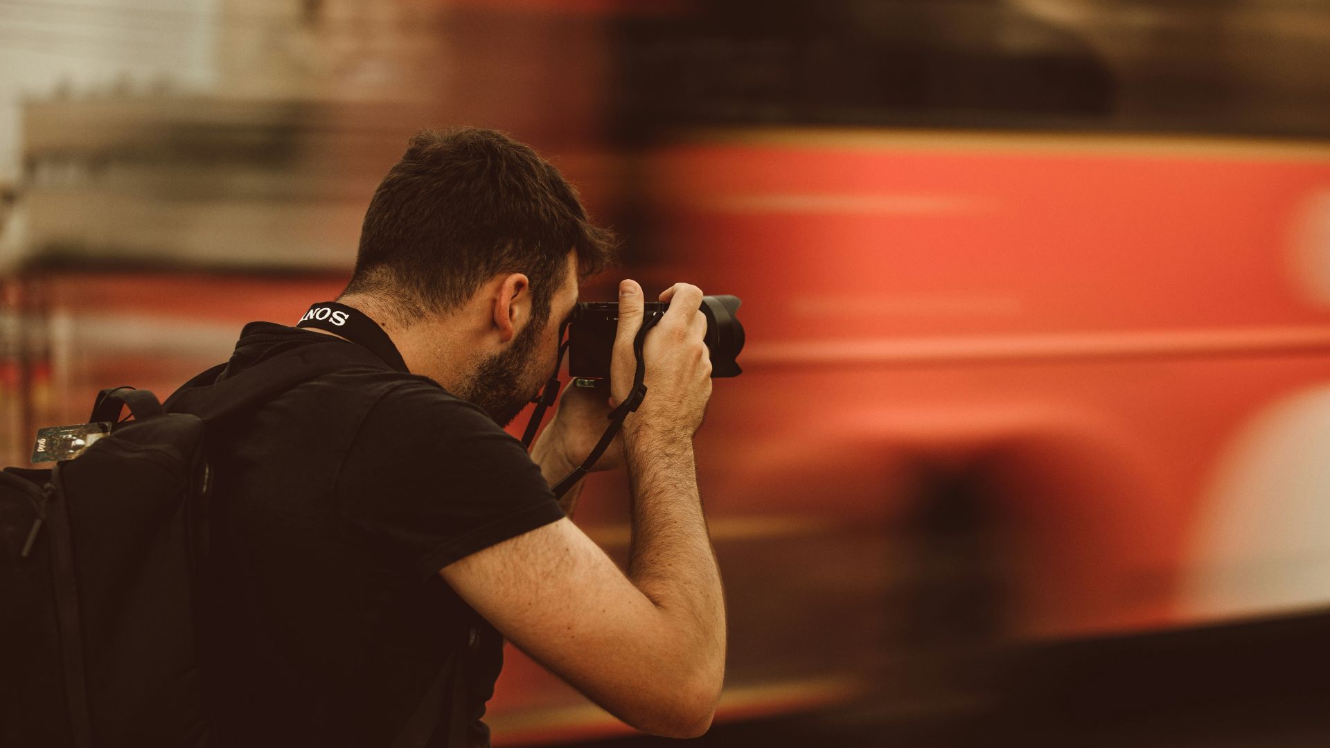 man in black t-shirt holding black camera