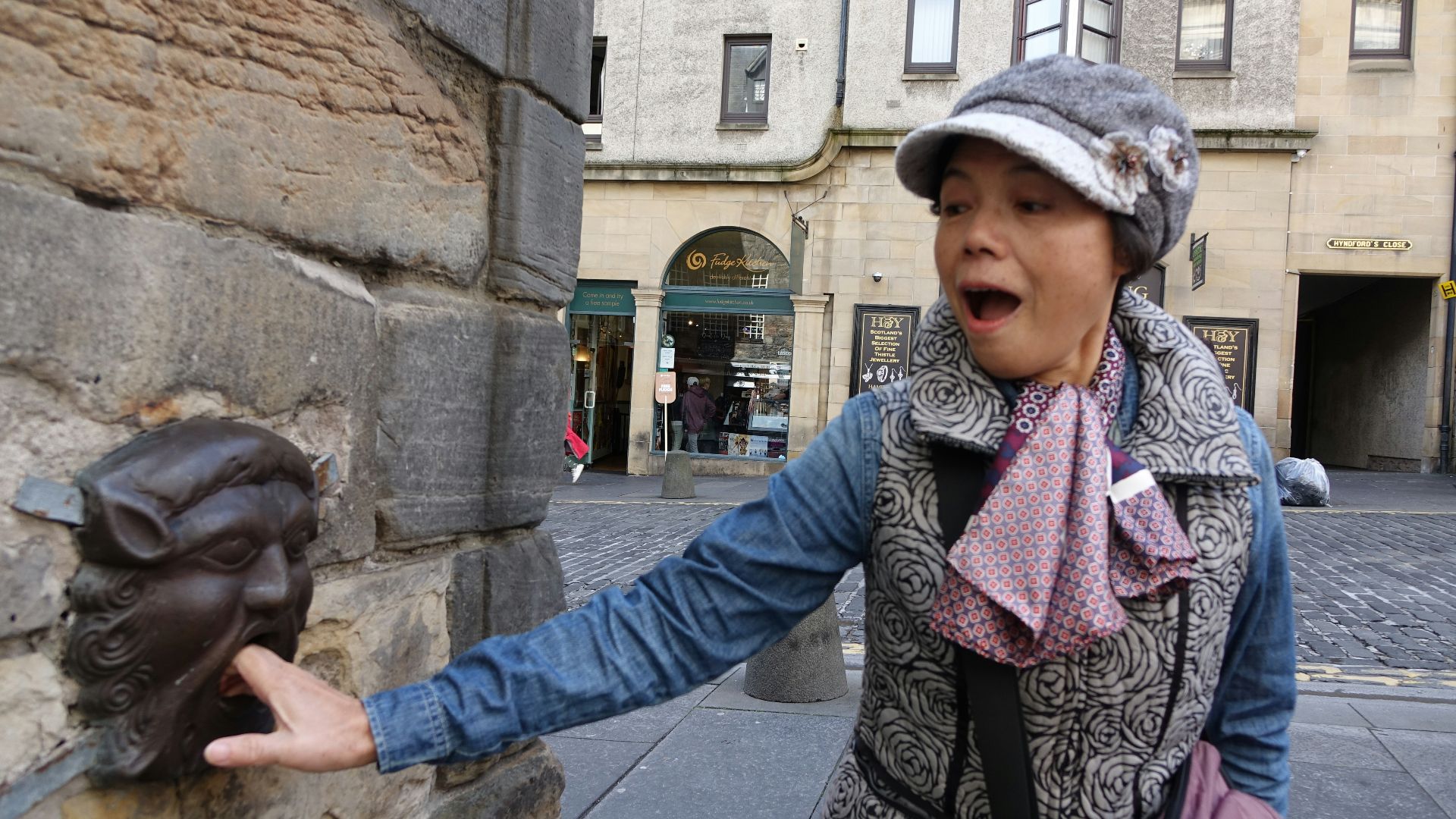 A woman standing next to a stone wall