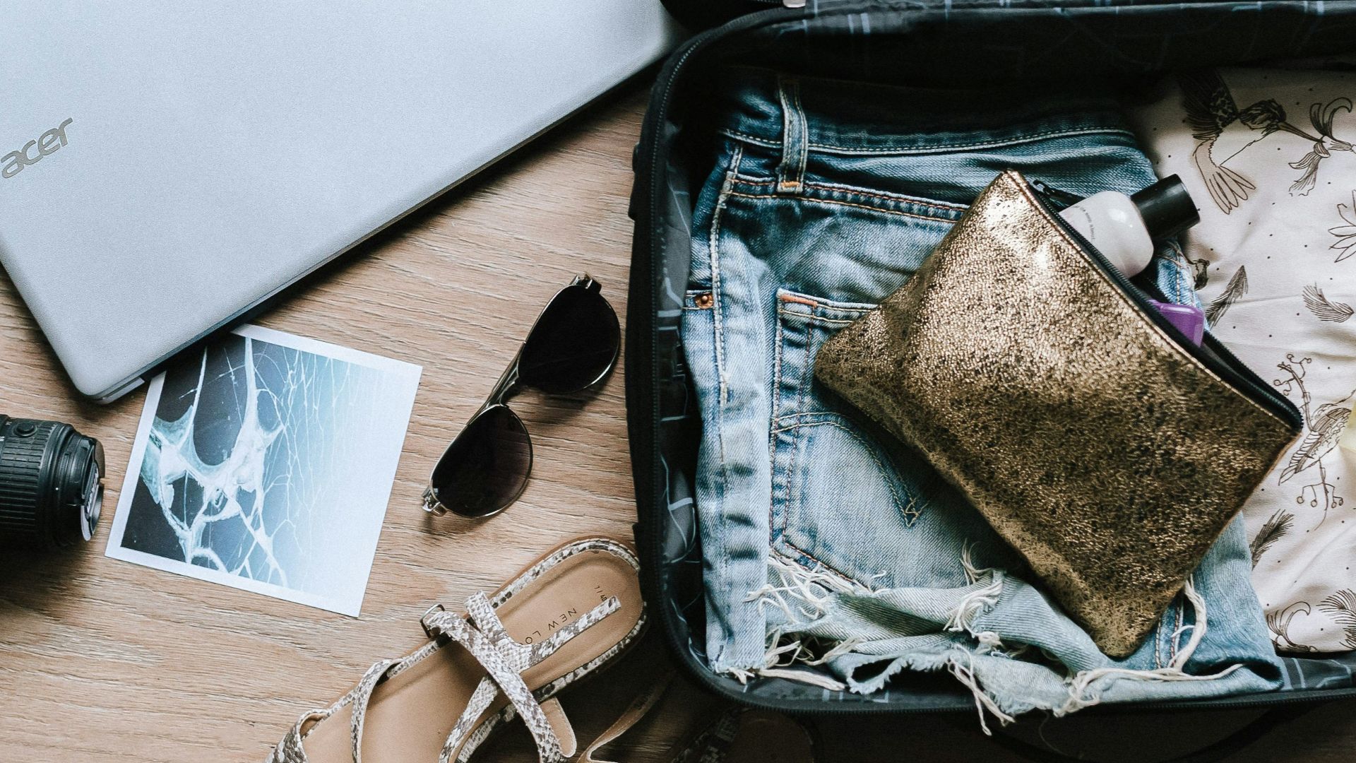 black DSLR camera near sunglasses and bag