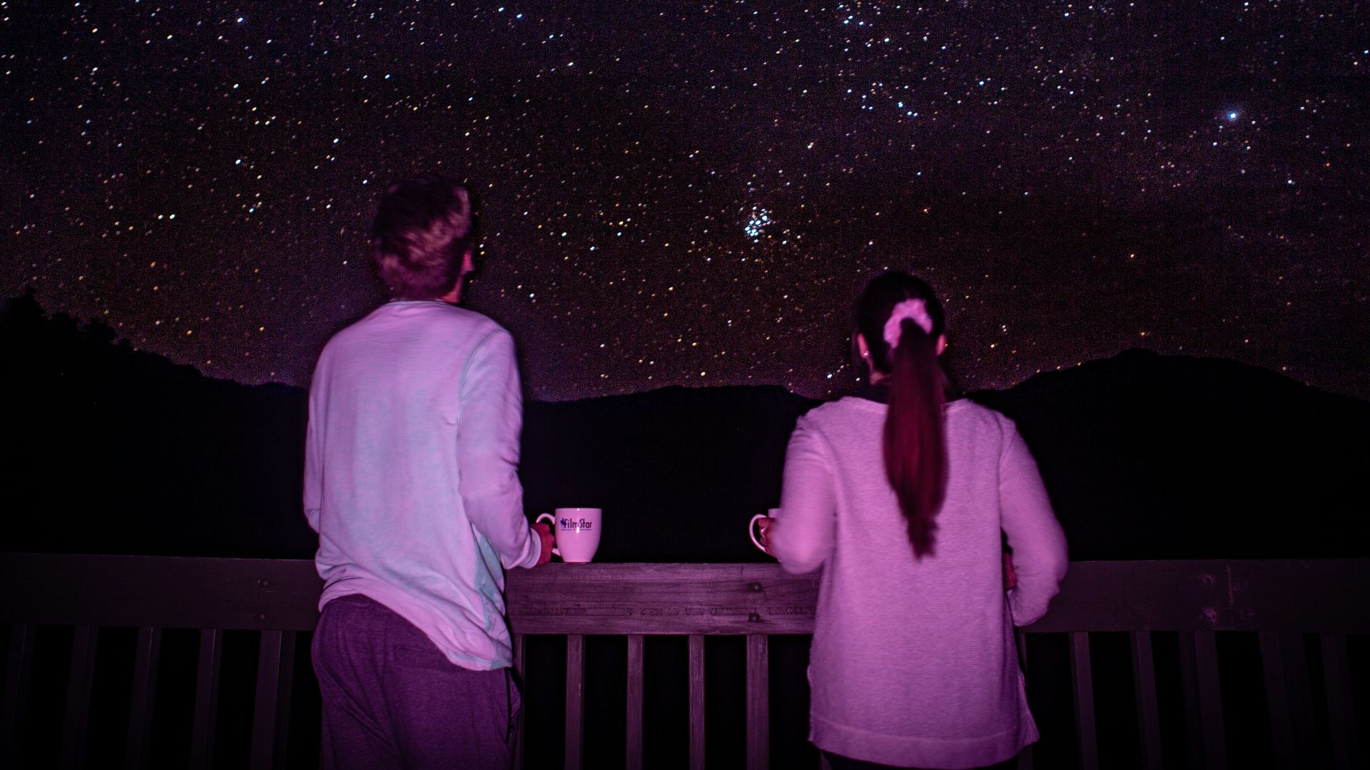 man and woman standing in front of galaxy