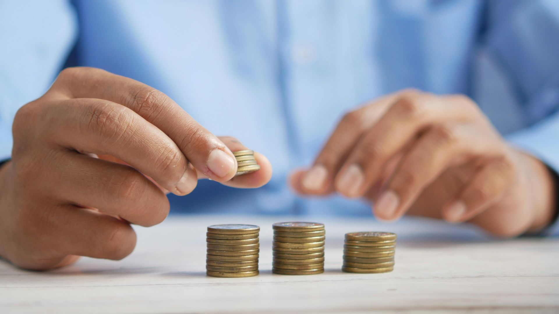 a person stacking coins on top of a table