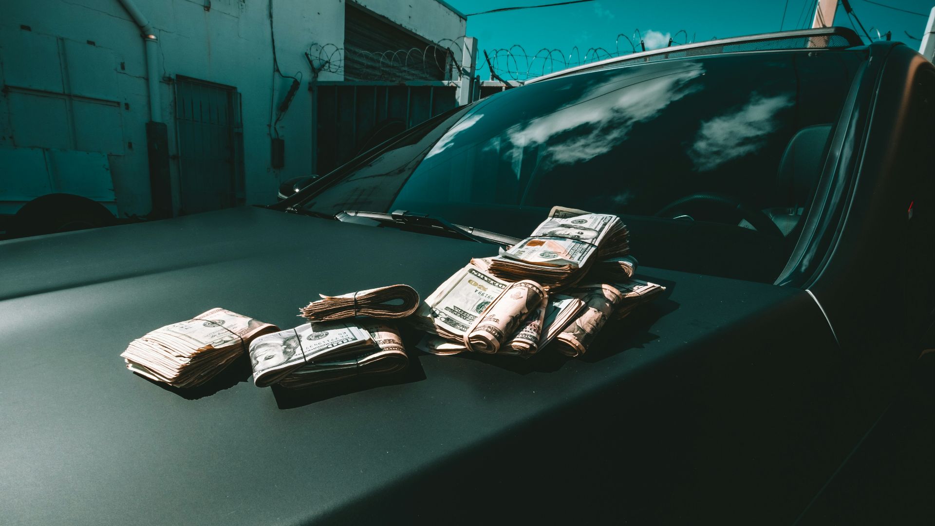 black car parked beside white building during daytime