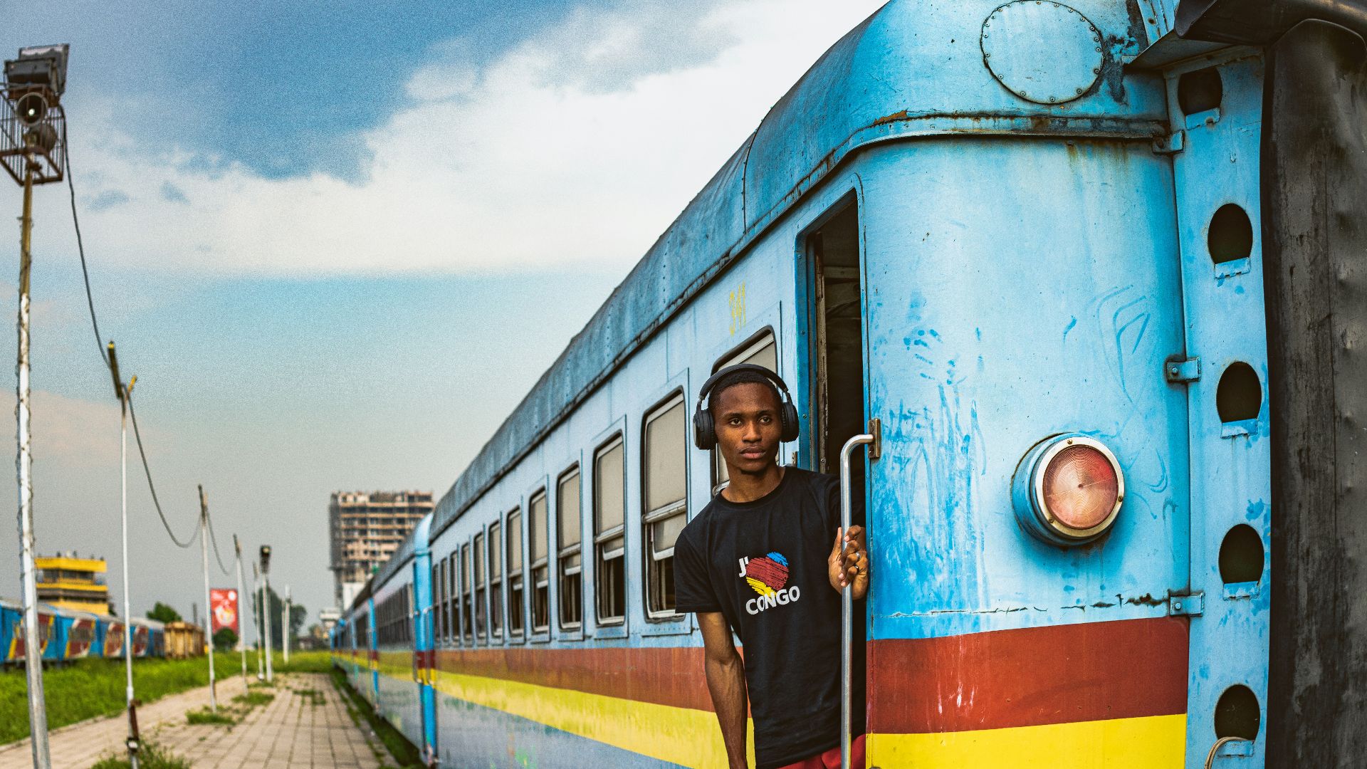 a man standing on the side of a blue train