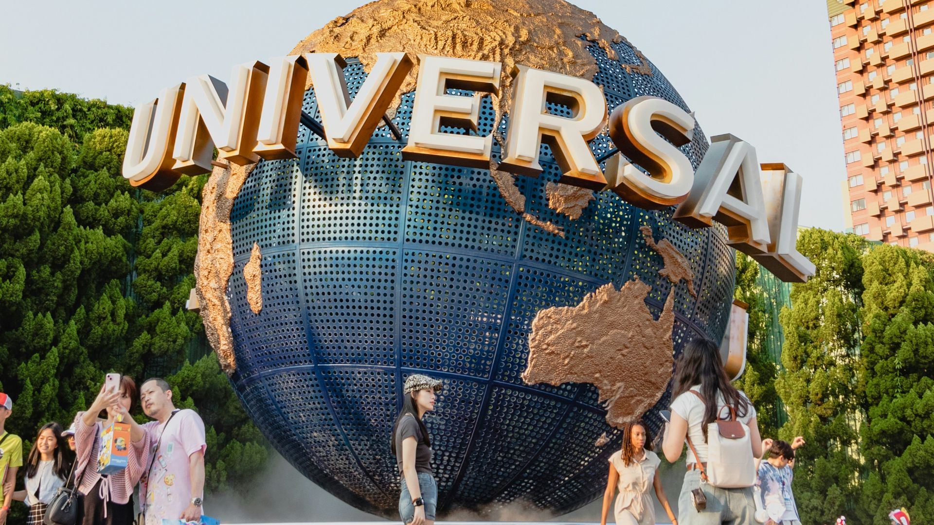 A group of people standing around a giant globe