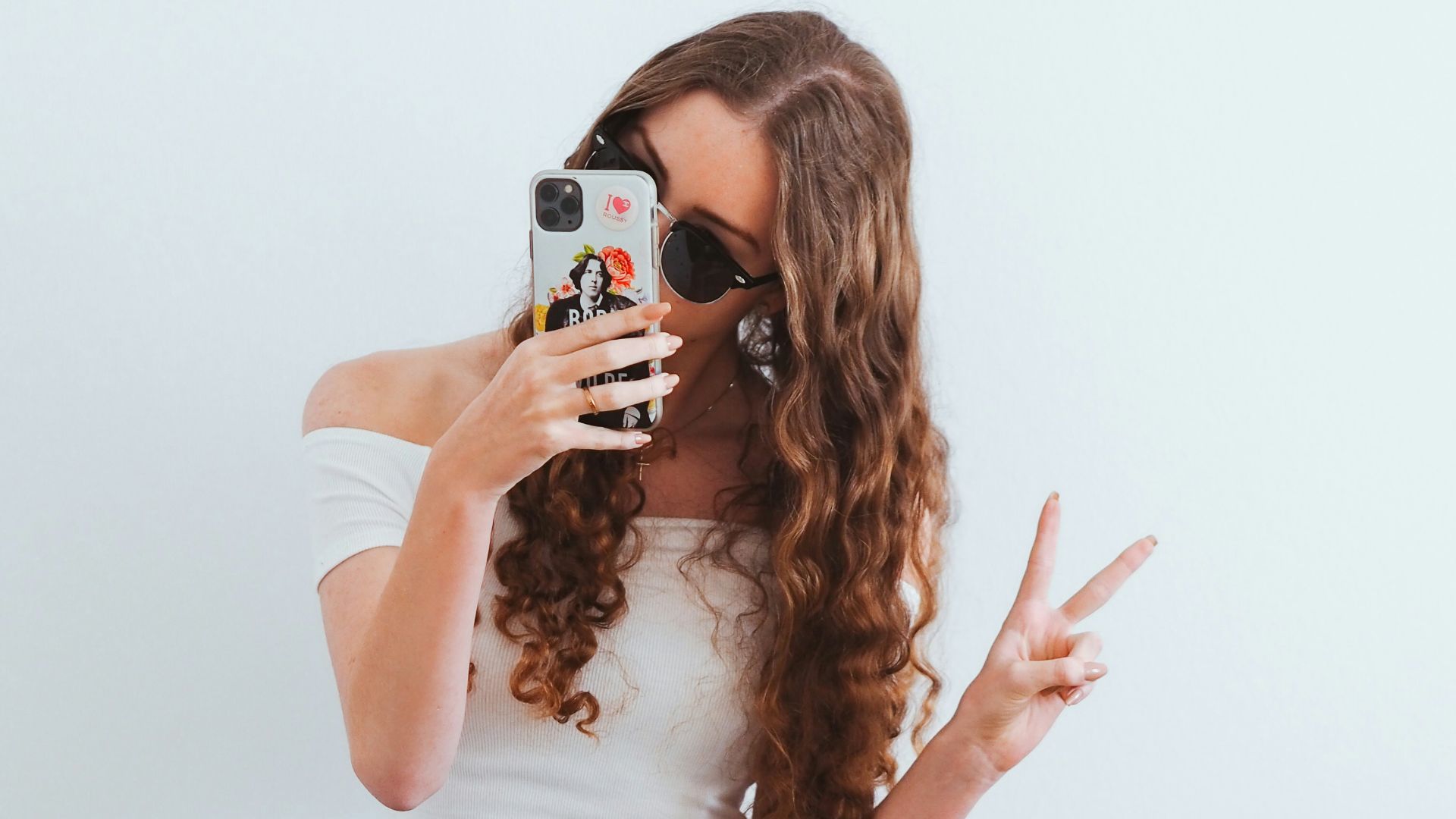 woman in pink tank top and blue denim jeans sitting on yellow chair