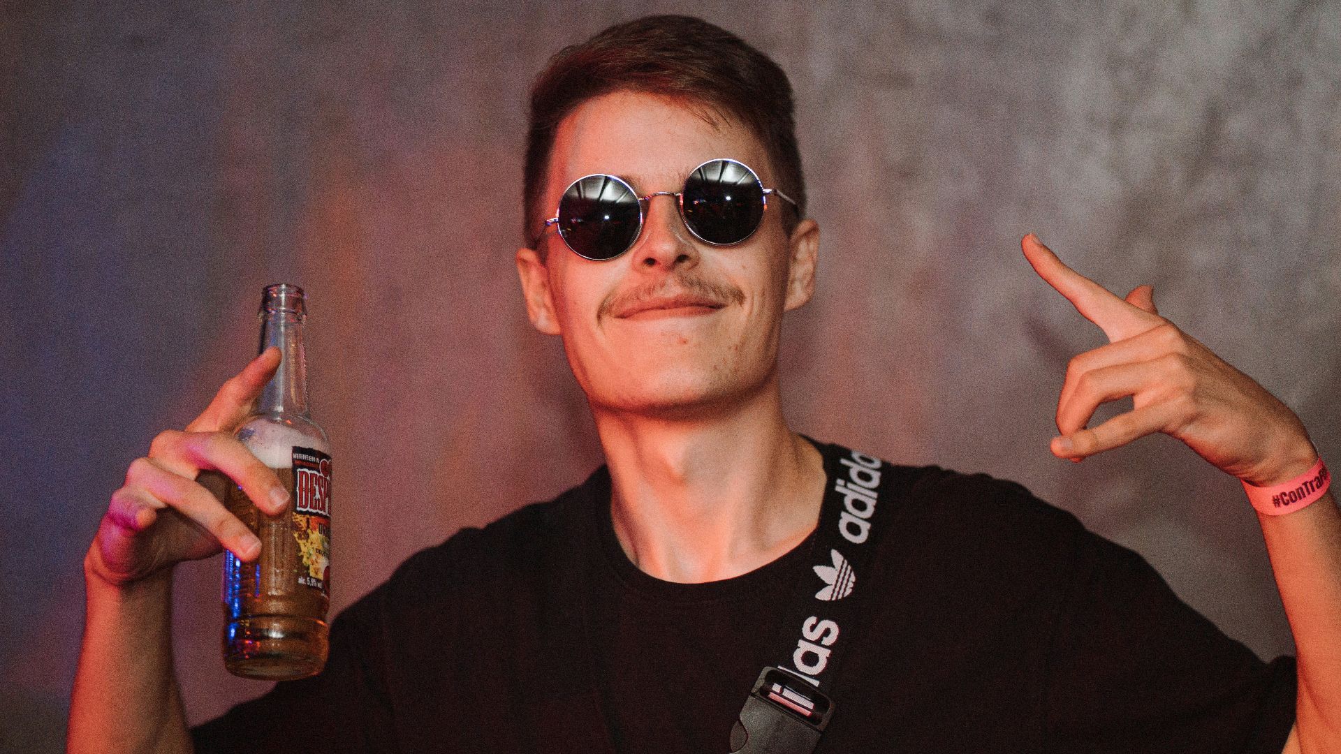 a person wearing sunglasses and holding a bottle of alcohol