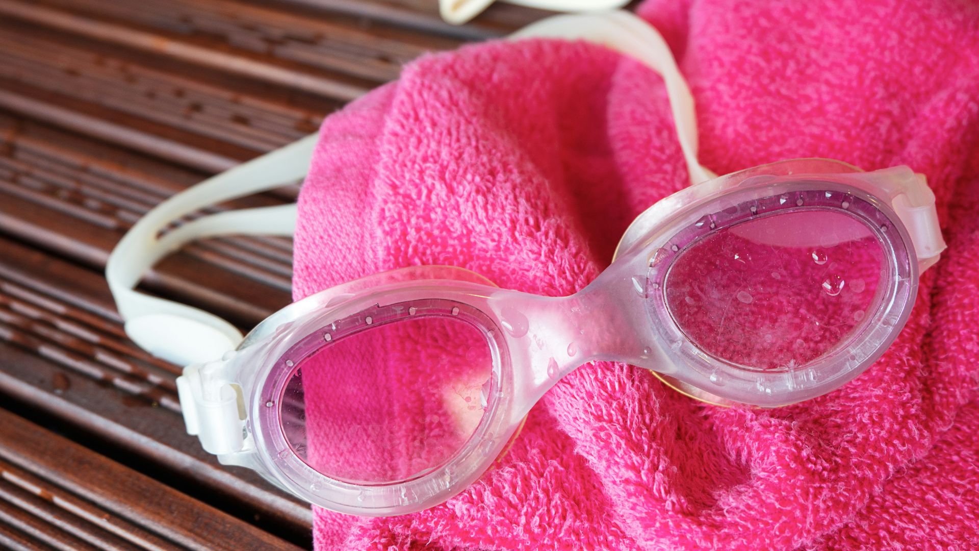 Swim goggles, towel, and a swim cap are displayed.