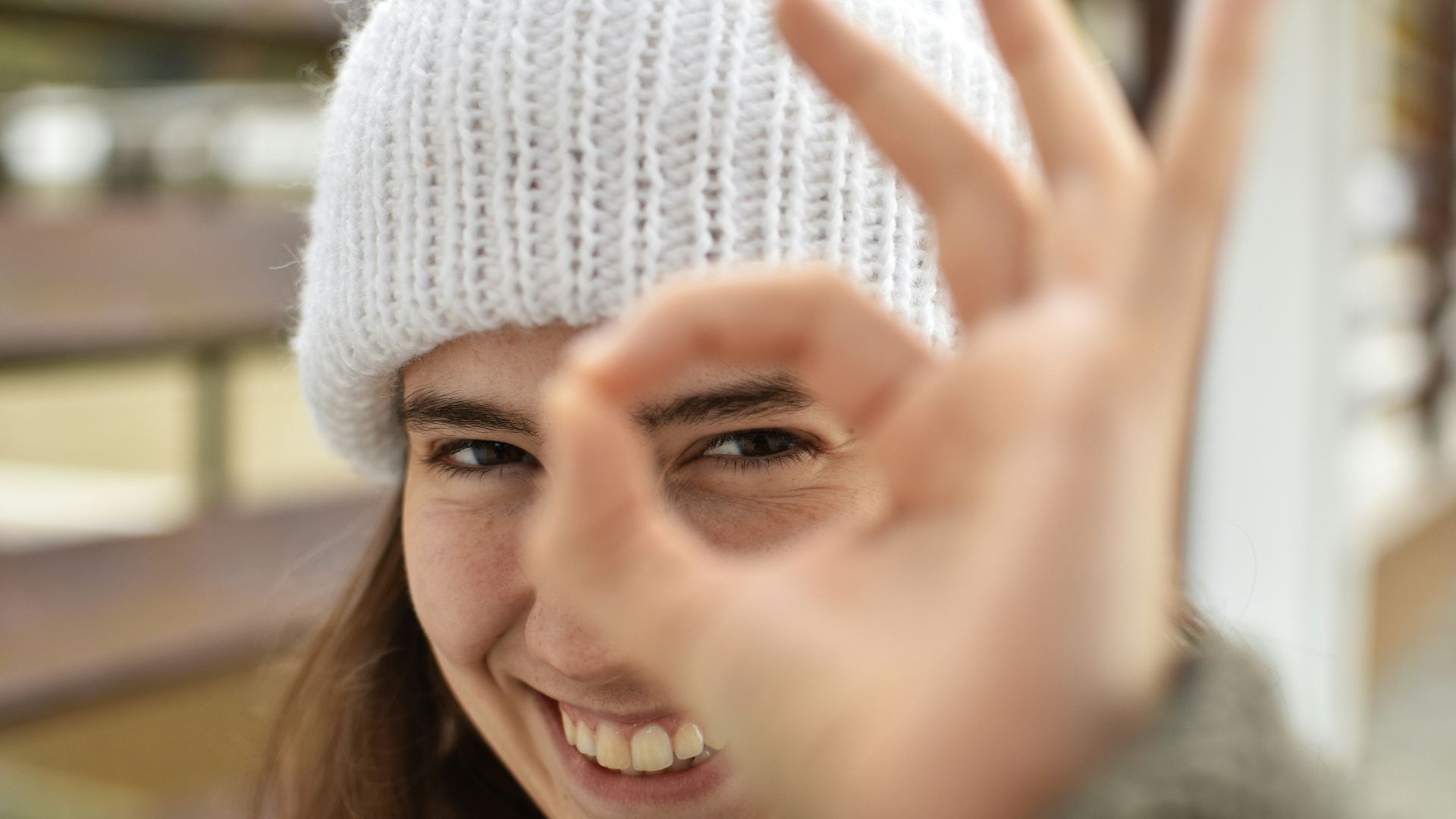 smiling woman wearing white knit cap