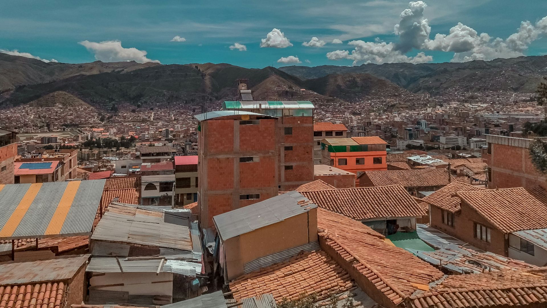 a city with many rooftops and mountains in the background