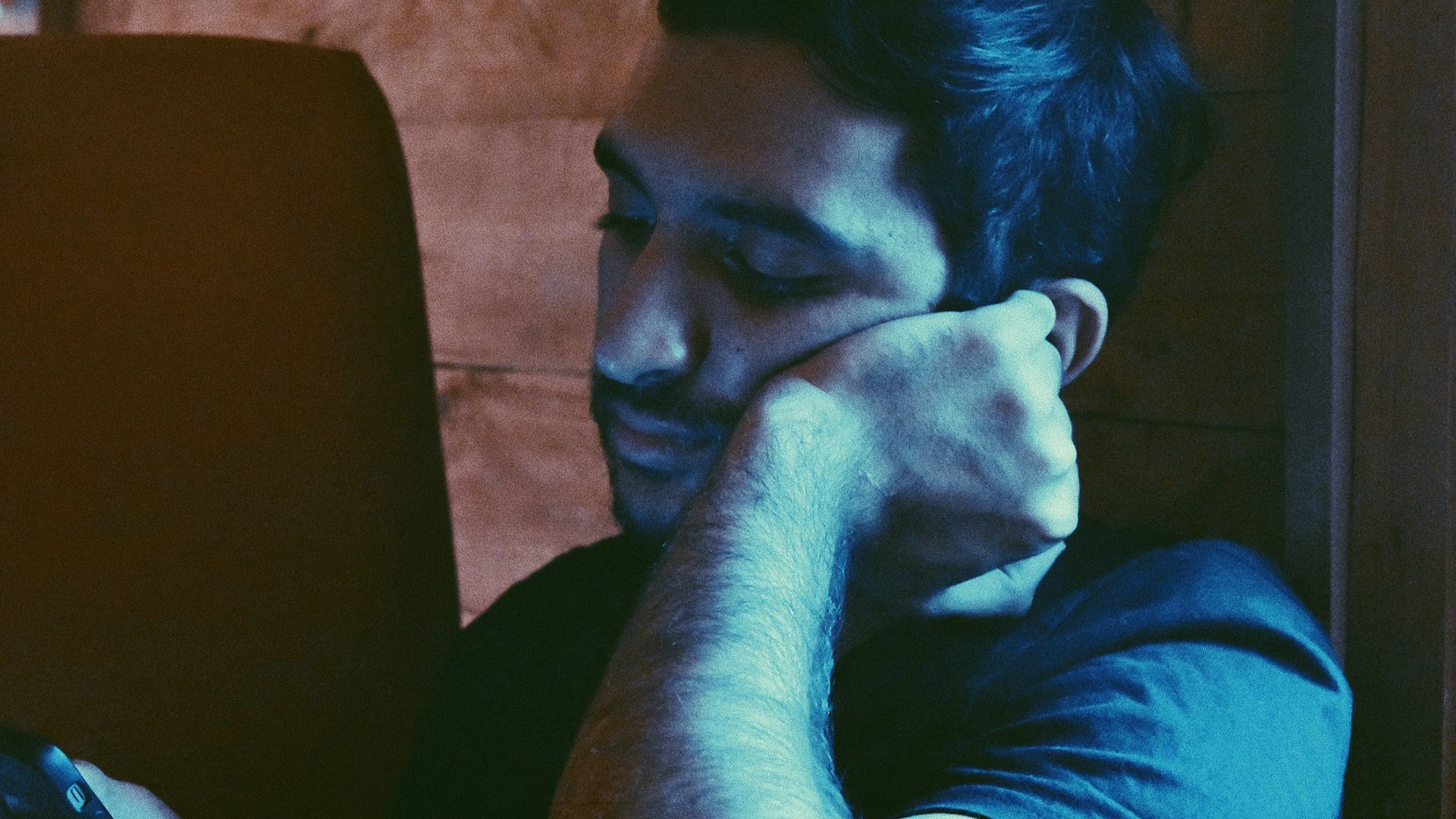 man leaning his face on his left hand