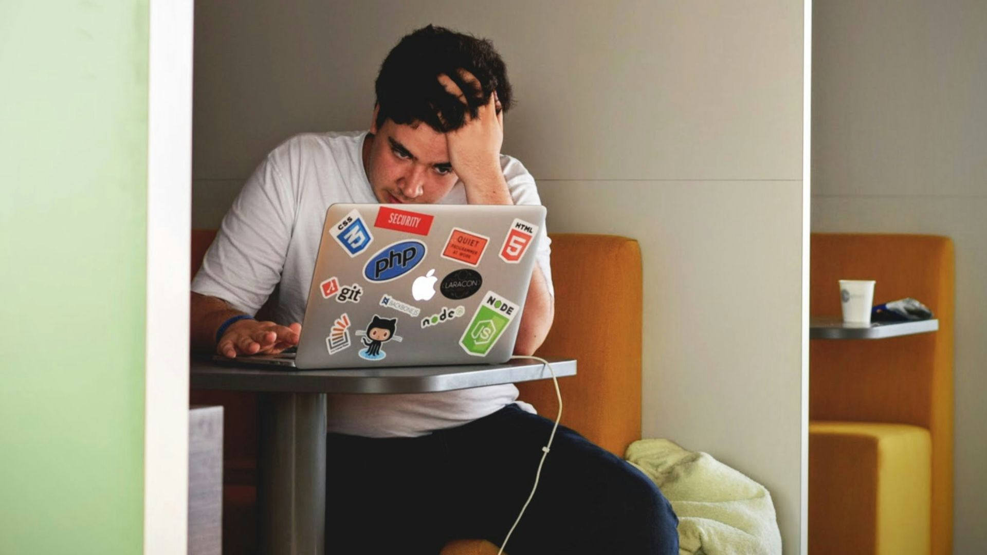 man wearing white top using MacBook
