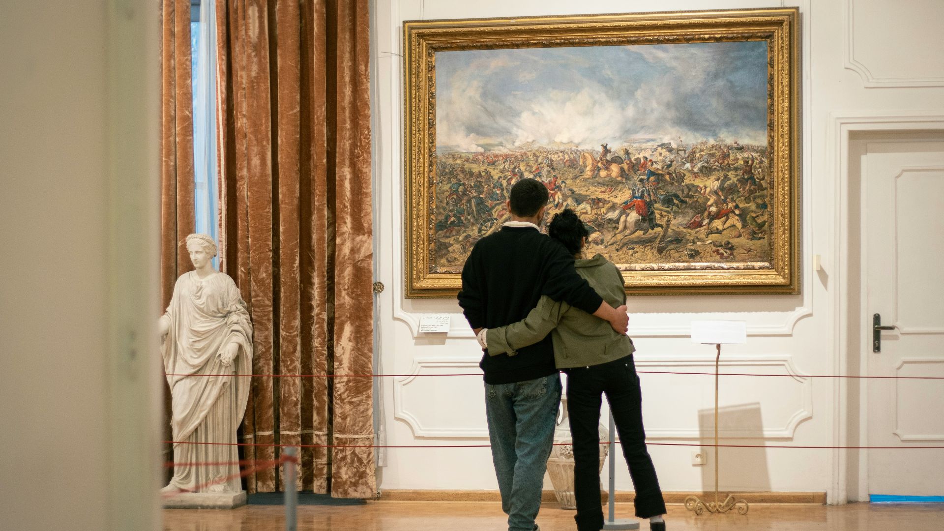a man and a woman standing in front of a painting