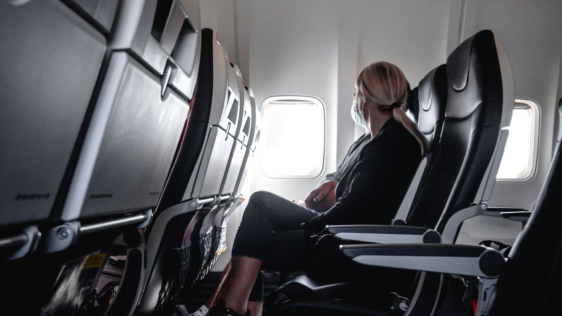 a woman sitting in a seat on an airplane