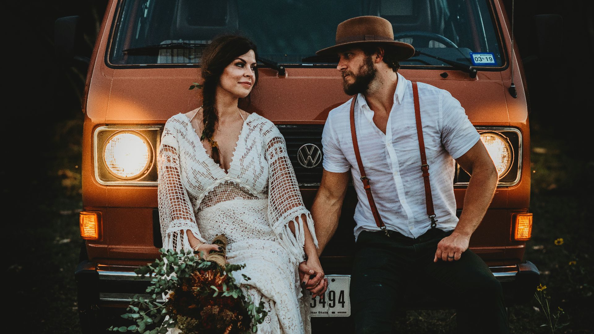 man holding hands of woman while leaning on brown Volkswagen vehicle