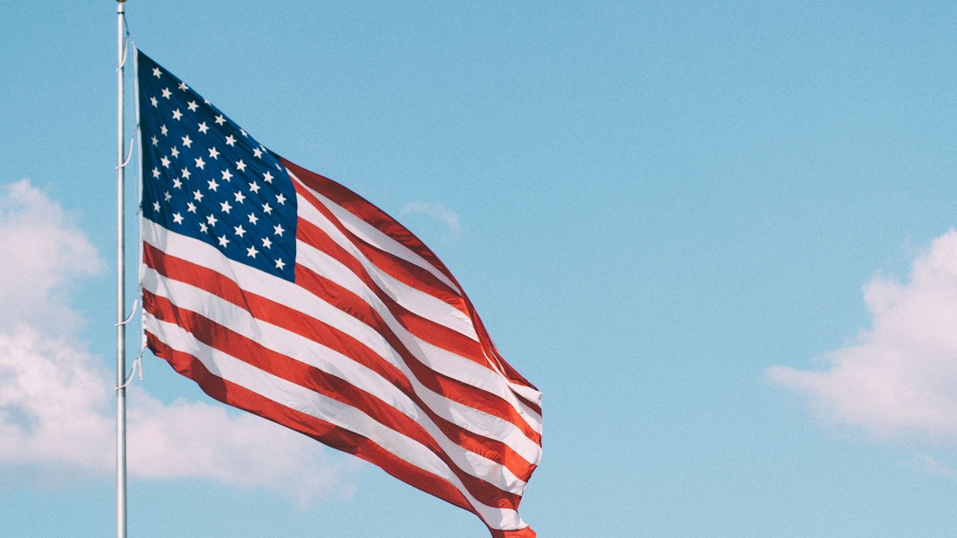 flag of U.S.A. under white clouds during daytime
