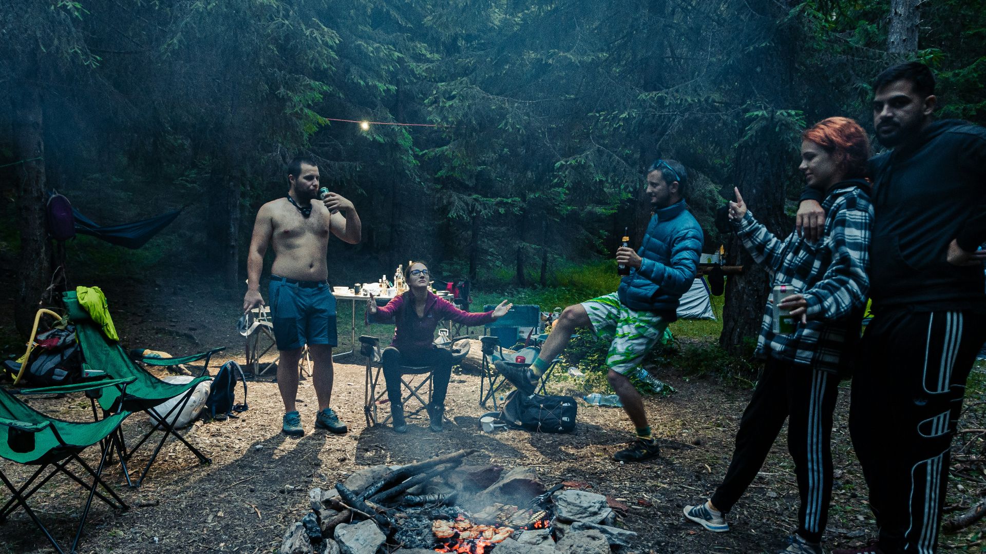 a group of people standing around a campfire