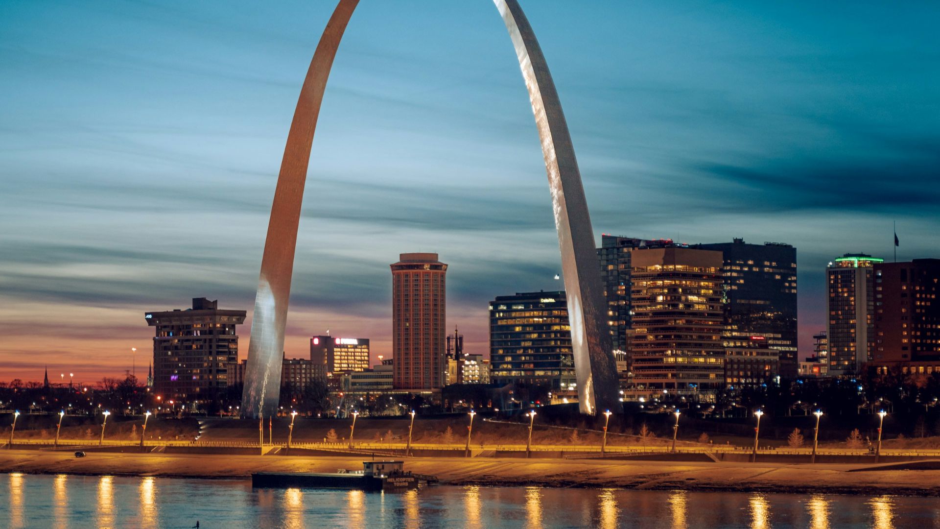 the st louis arch is lit up at night