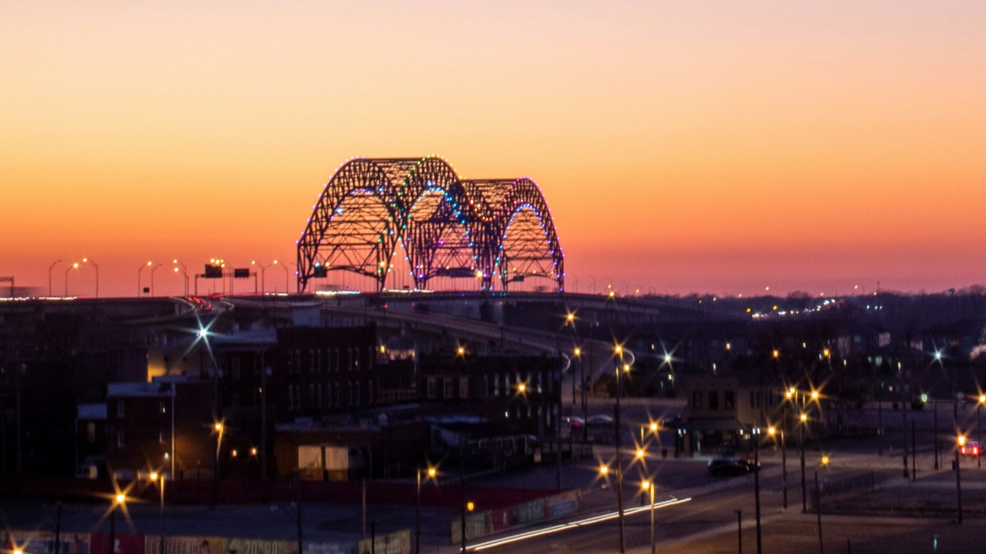 a sunset view of a large pyramid with a ferris wheel in the background