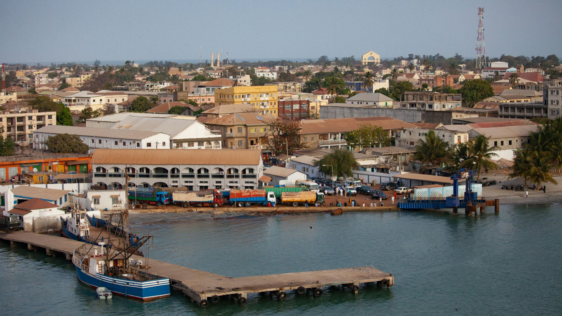 white and blue boat on water near houses during daytime