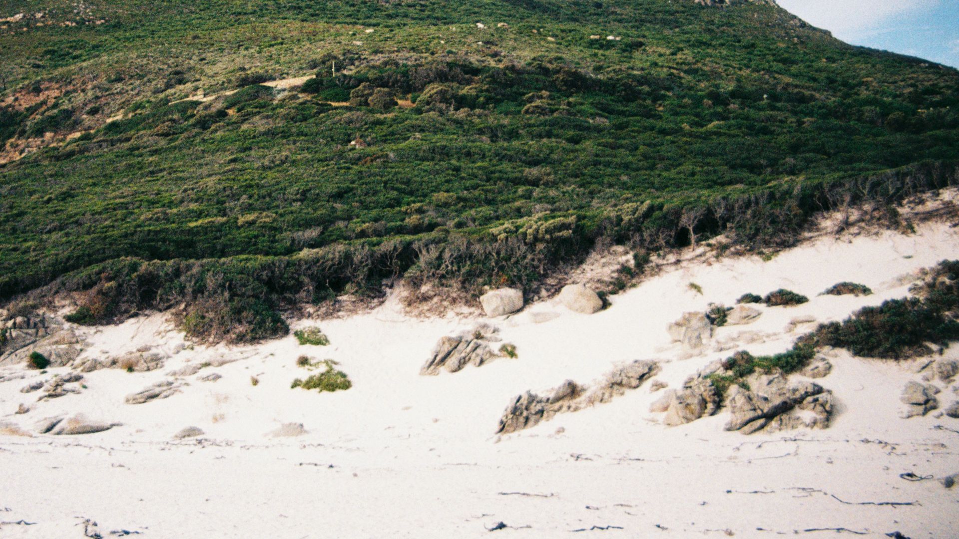 a rocky hill with a grassy hill
