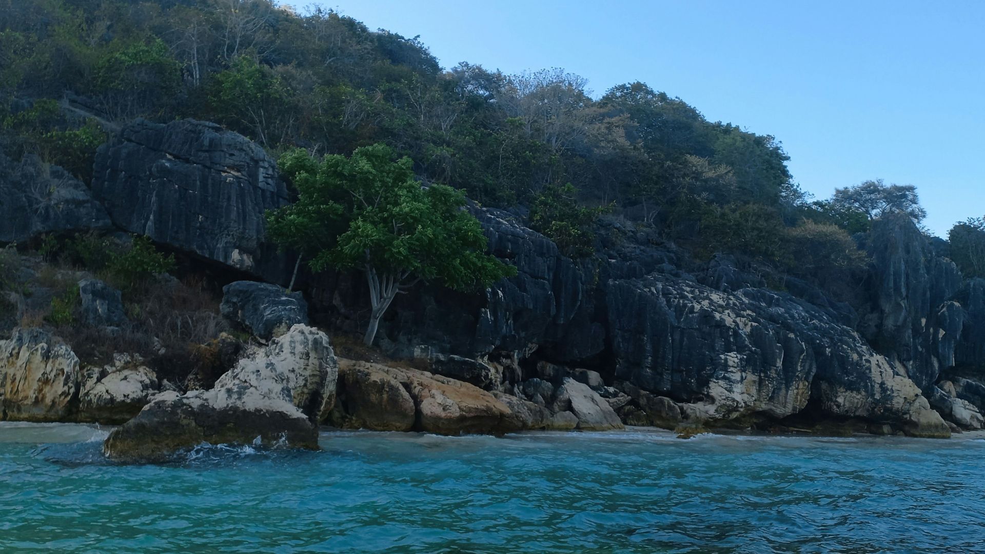 a body of water next to a rocky cliff