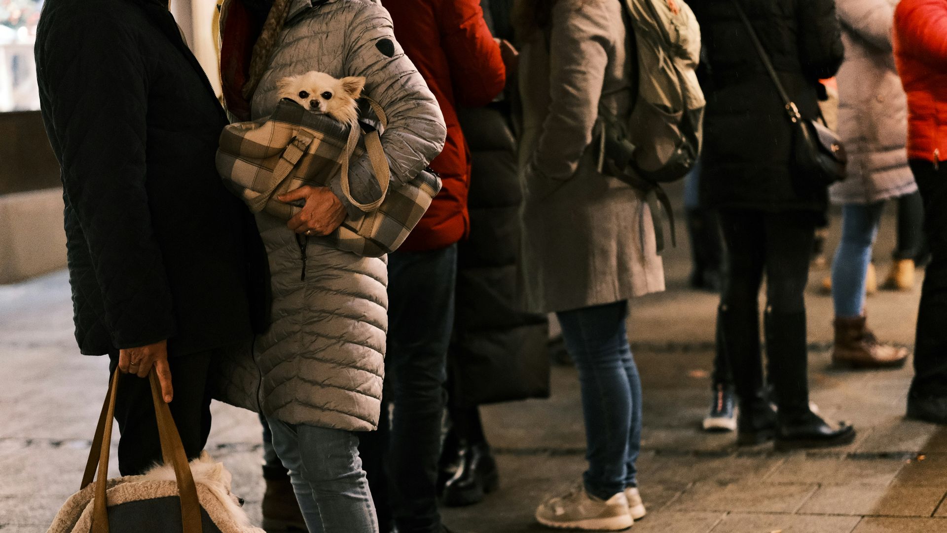 a group of people standing next to each other on a sidewalk