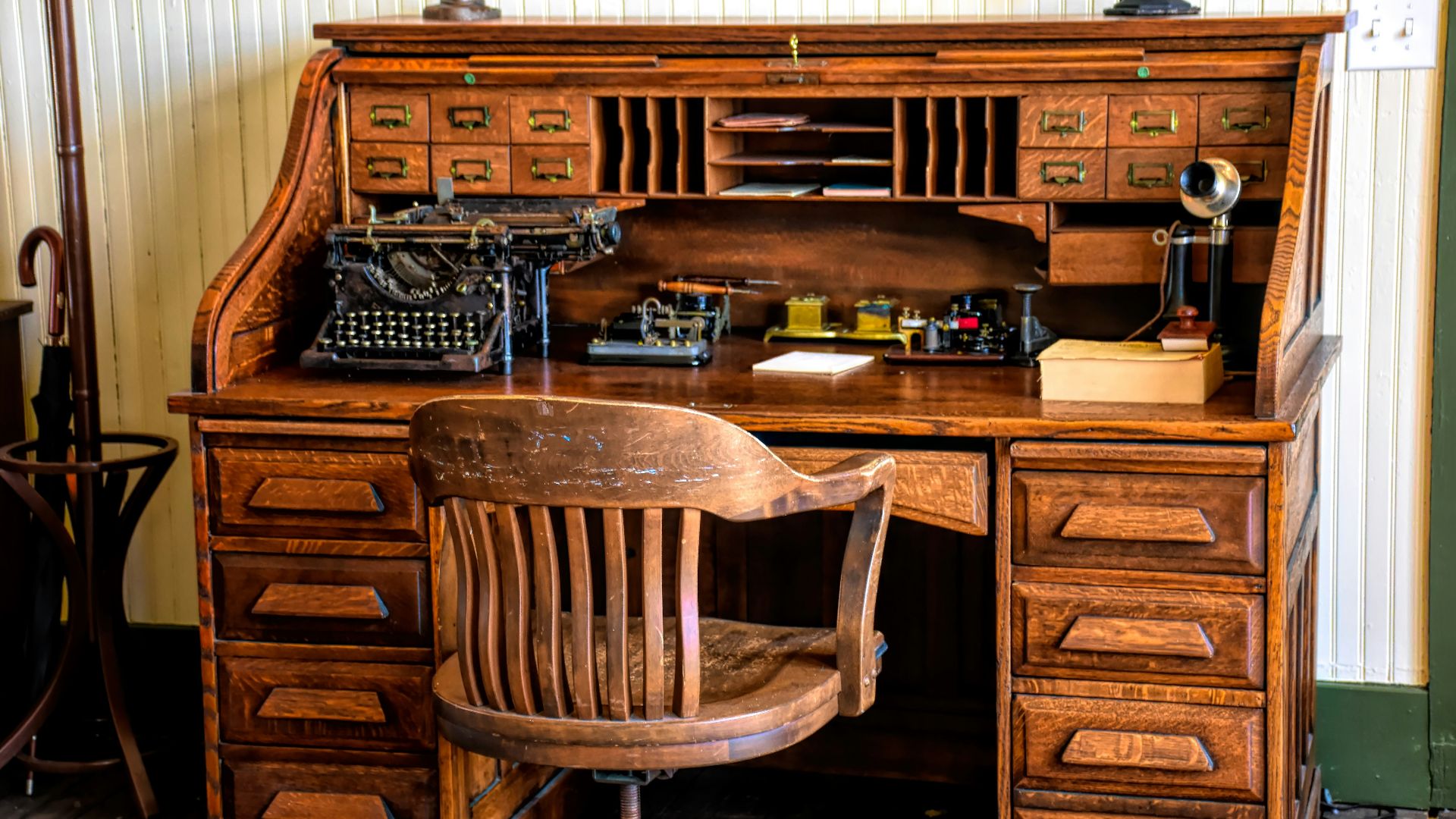 a desk with a chair and a typewriter on it