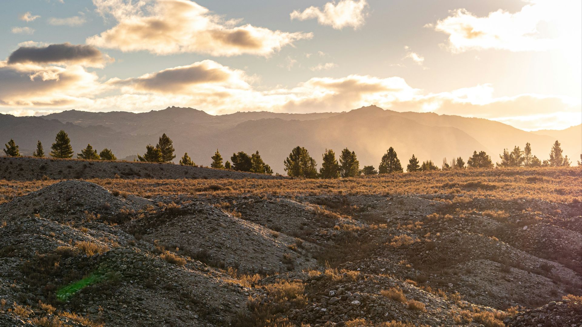 the sun is setting over the mountains in the distance