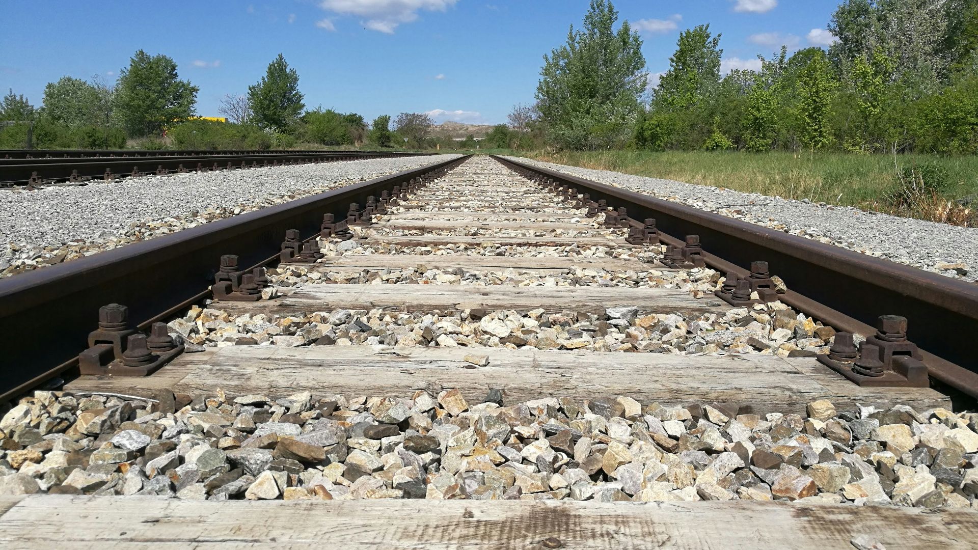 gray and black train rail under blue sky during daytime