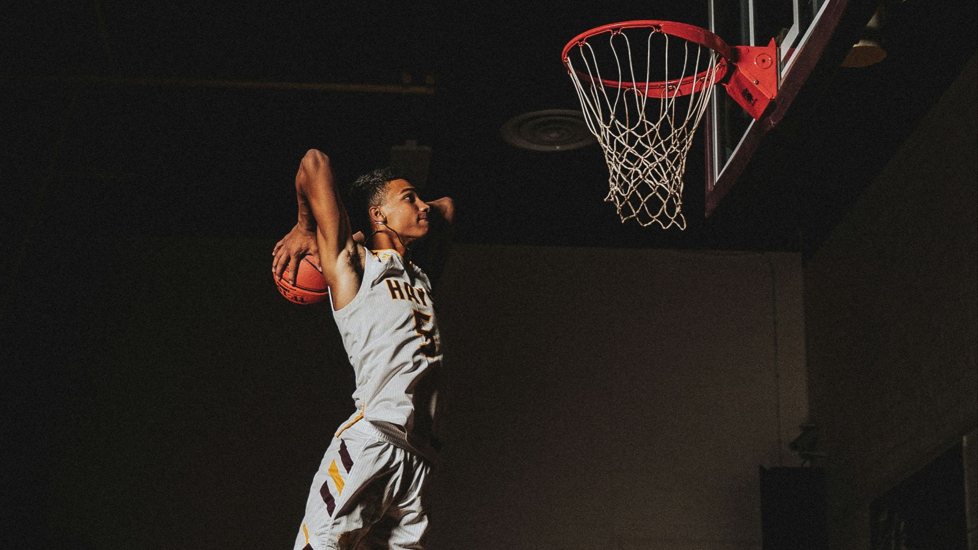 2 boys playing basketball on basketball court
