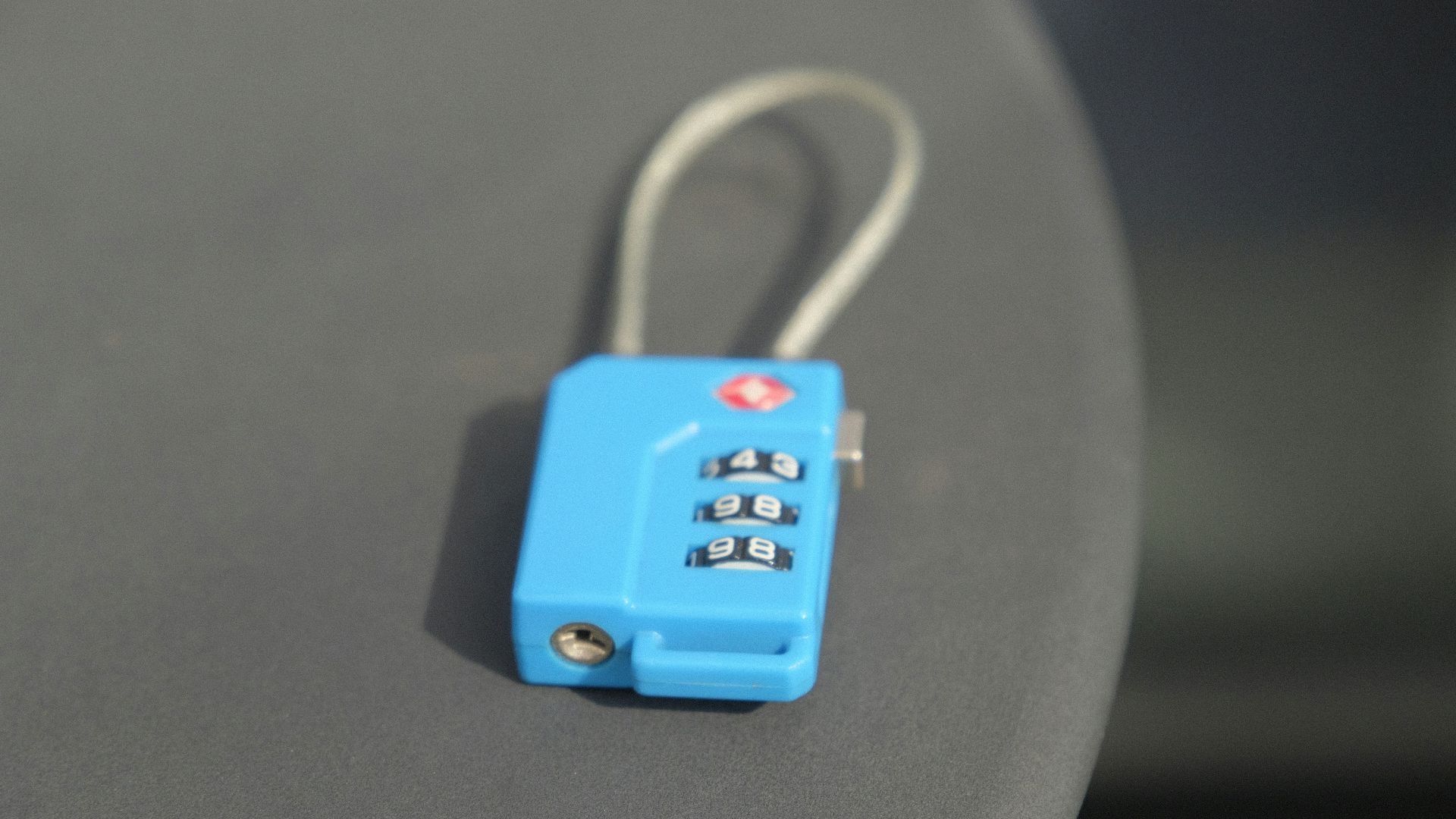 A small blue combination lock rests on a surface.