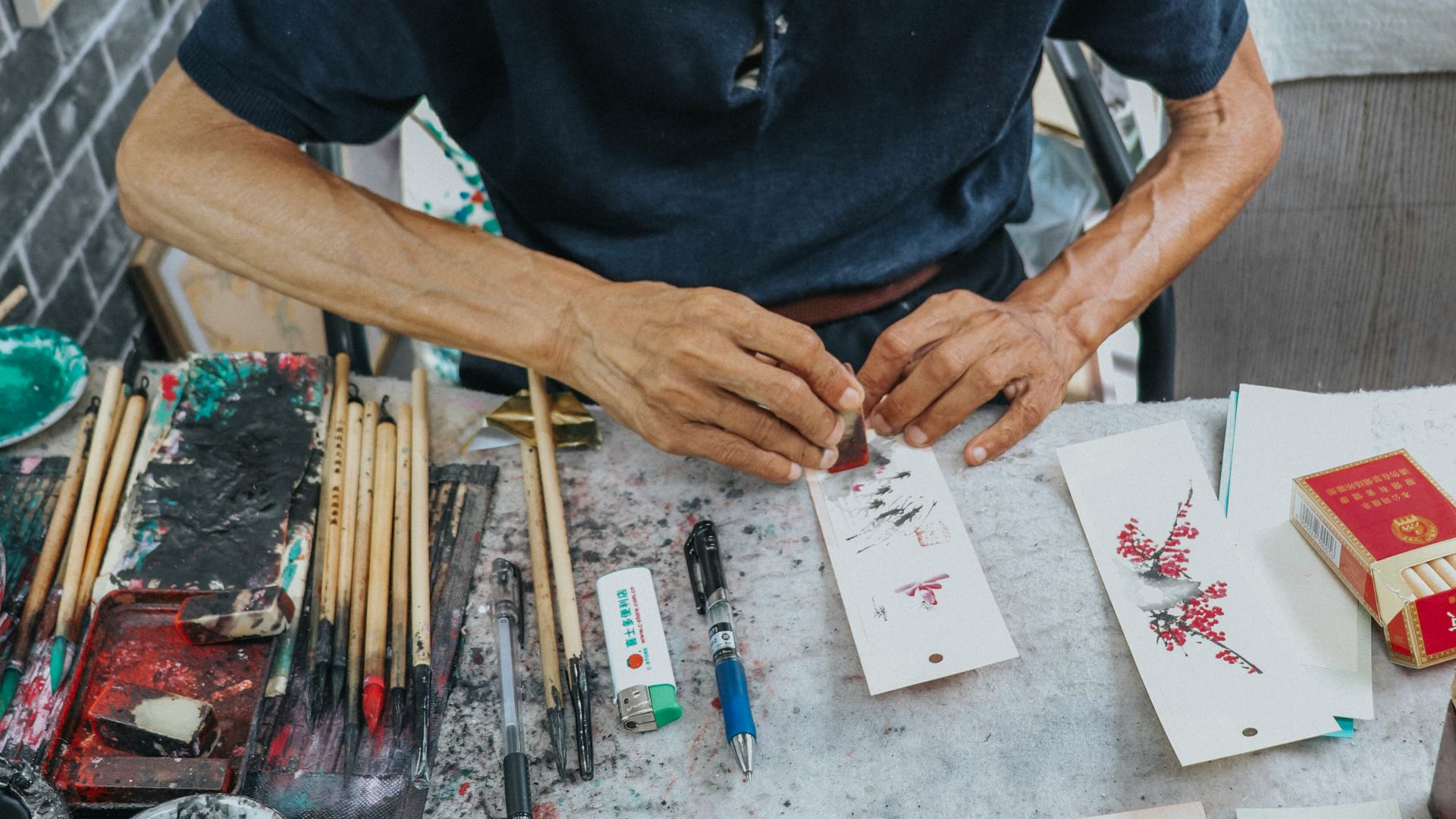 man in black crew neck t-shirt writing on white paper