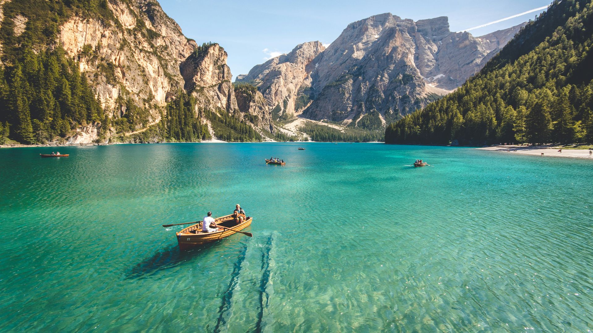 three brown wooden boat on blue lake water taken at daytime