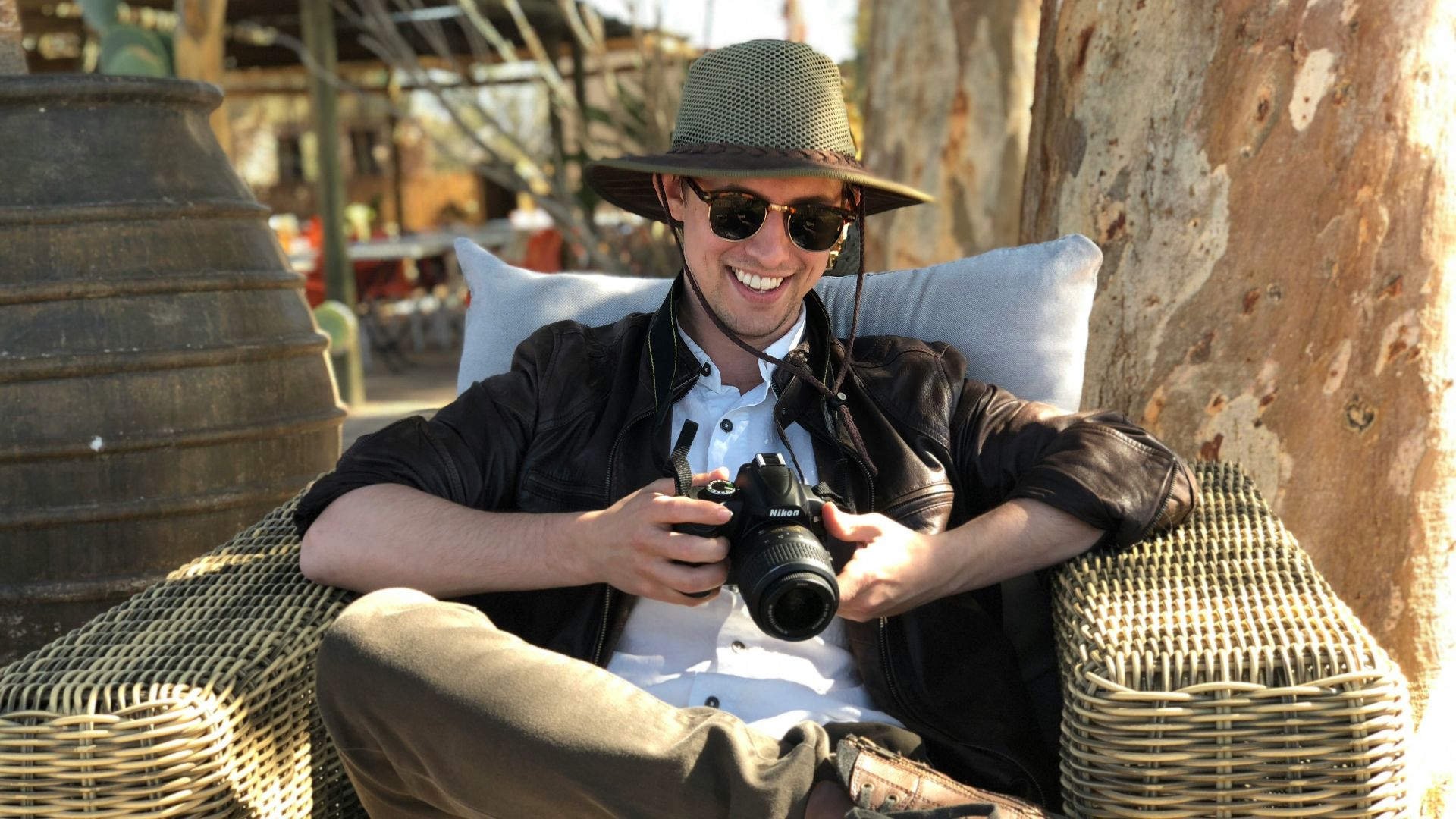 man sitting on chair while holding camera