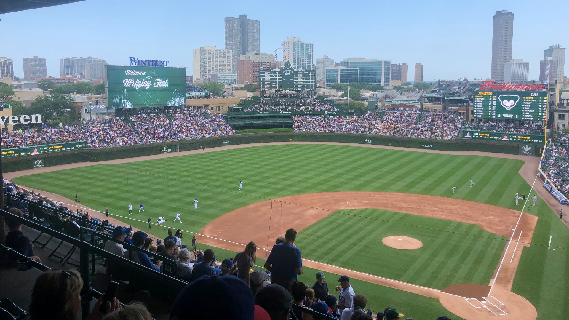 a baseball stadium with a full crowd with Wrigley Field in the background