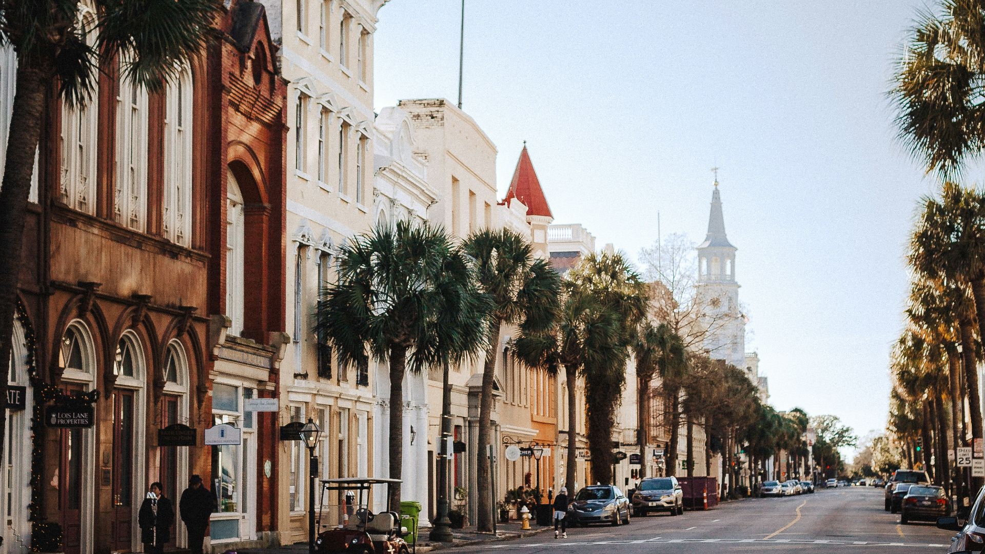 a street lined with tall buildings and palm trees