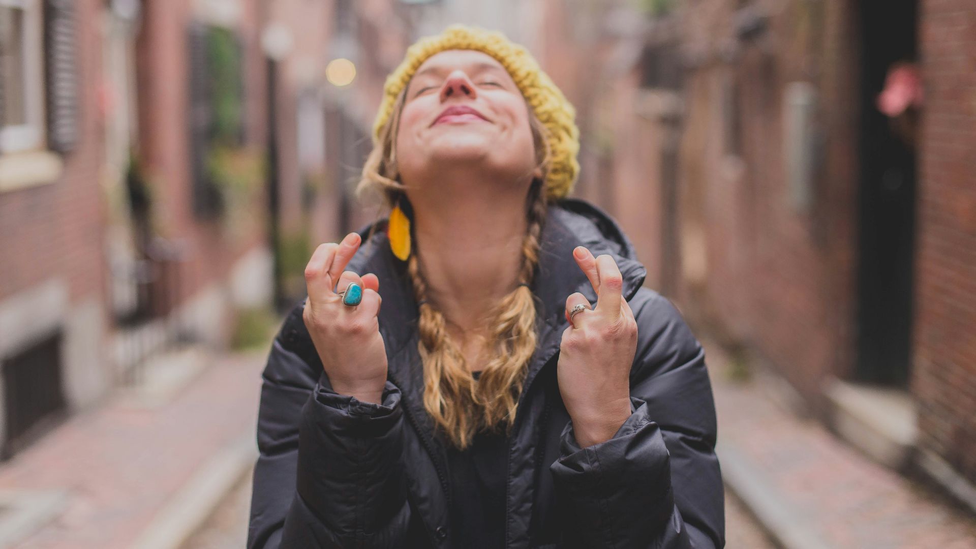 woman in black jacket wearing yellow knit cap