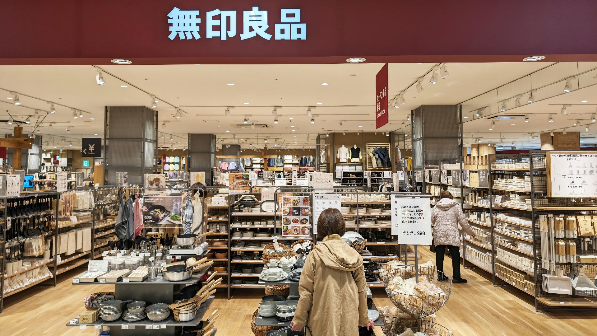 a woman standing in front of a store filled with items