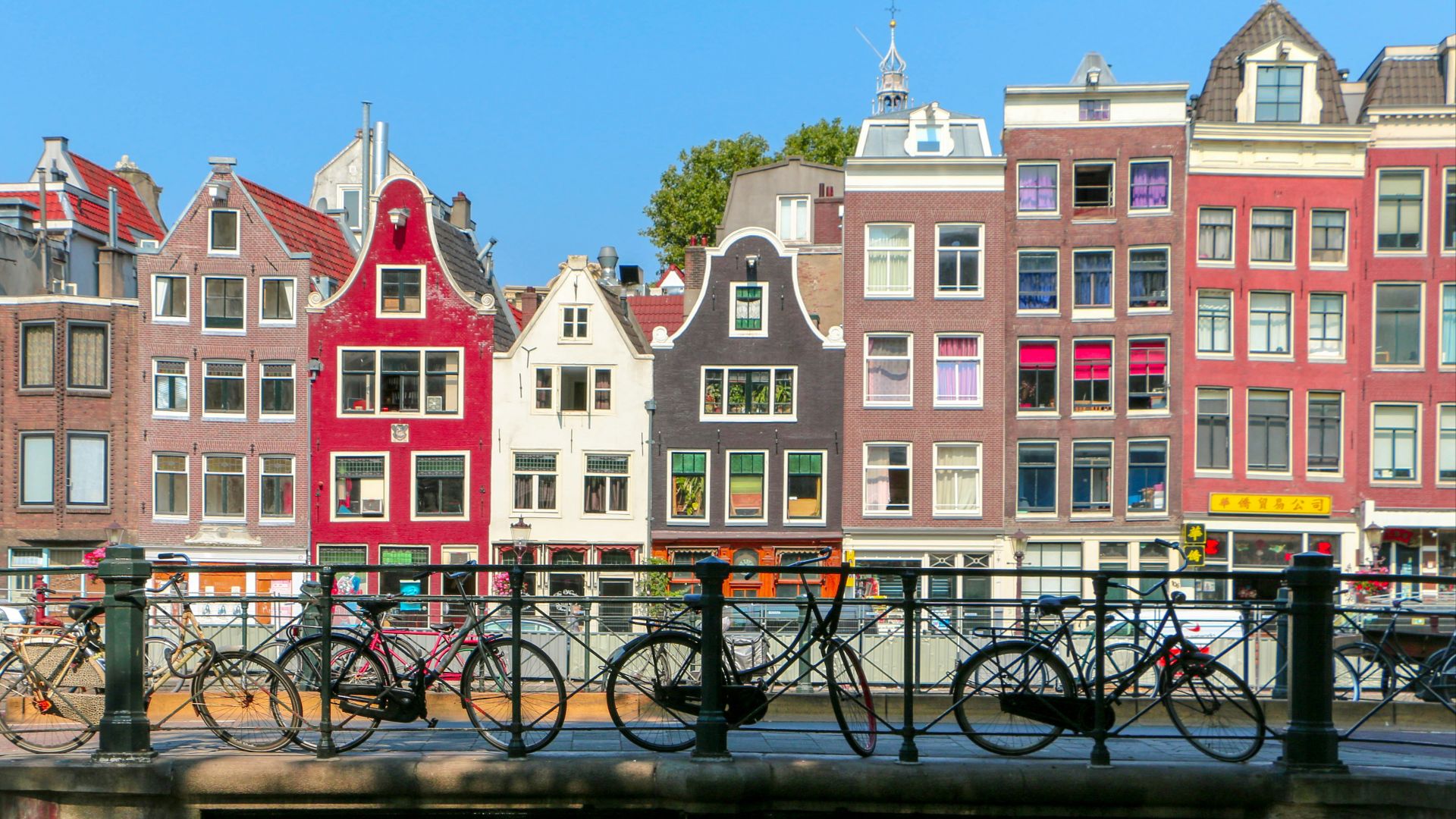 black bicycle leaning on black metal fence