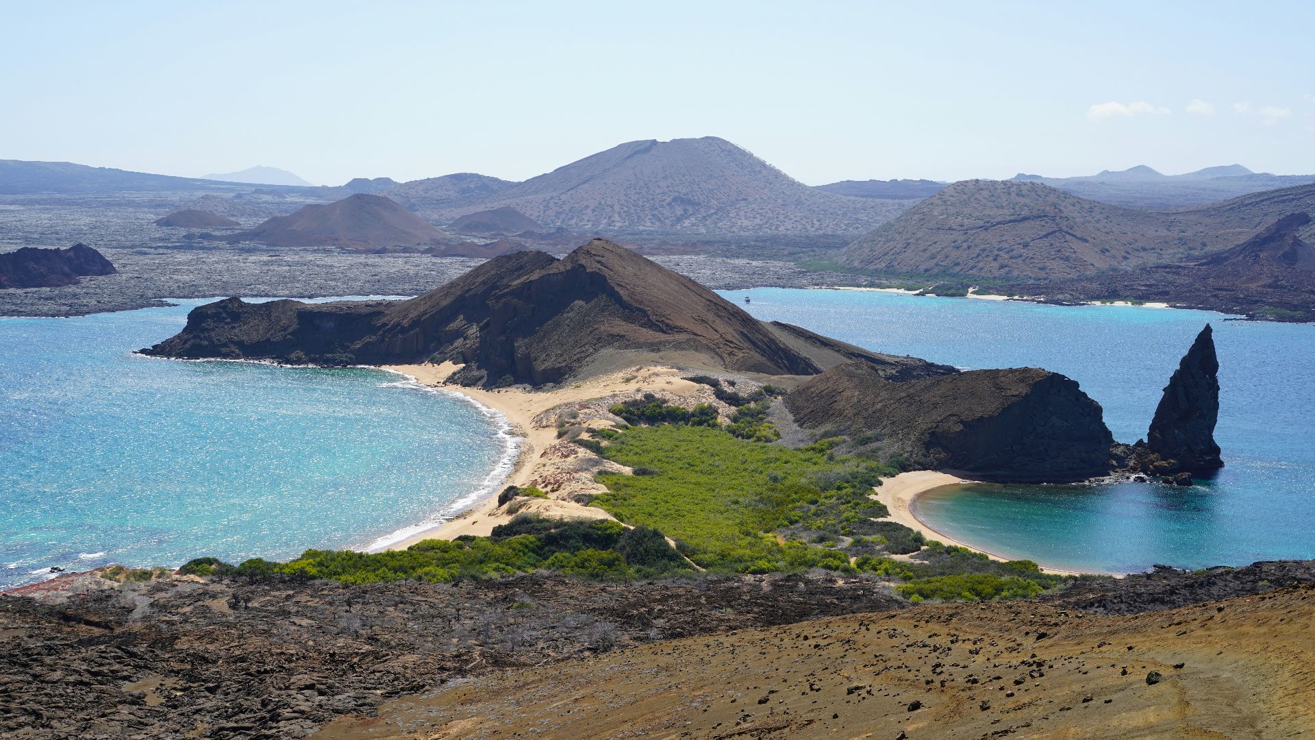 an island with a sandy beach and blue water