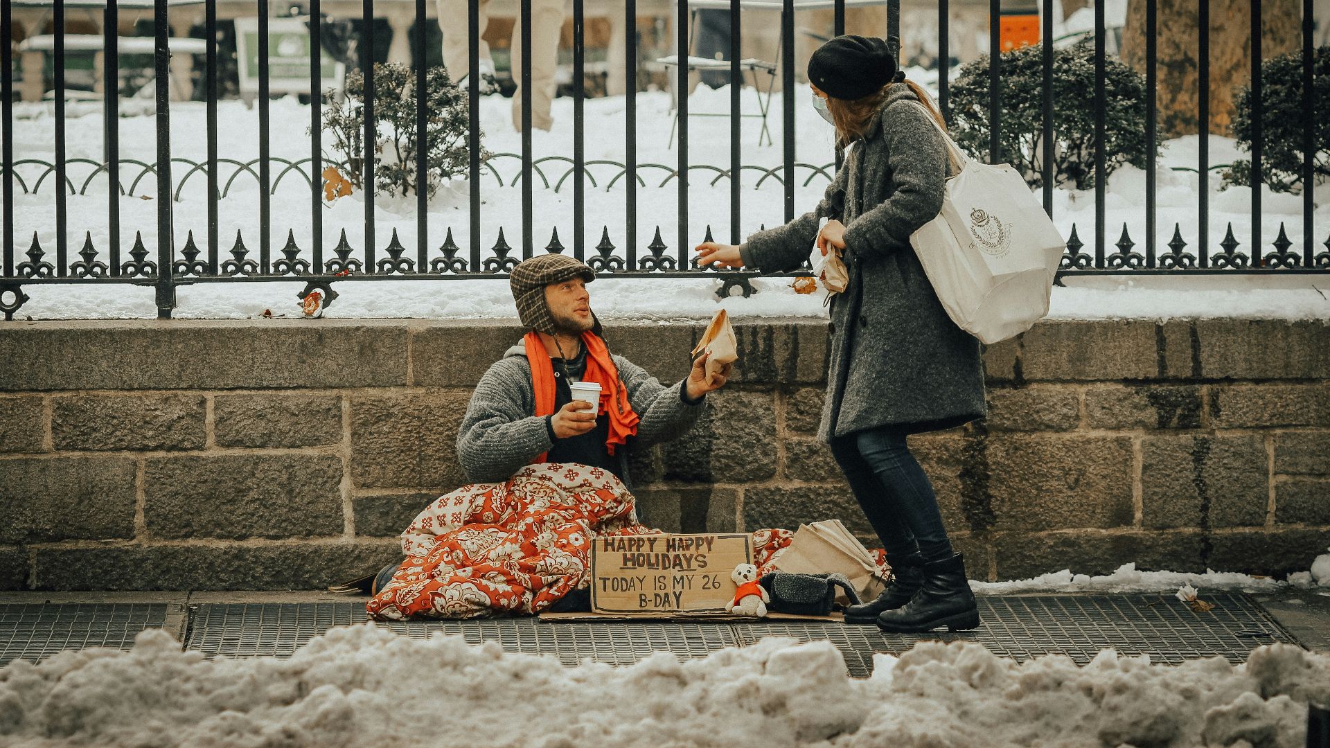 man in black jacket and black pants sitting on white snow covered ground during daytime