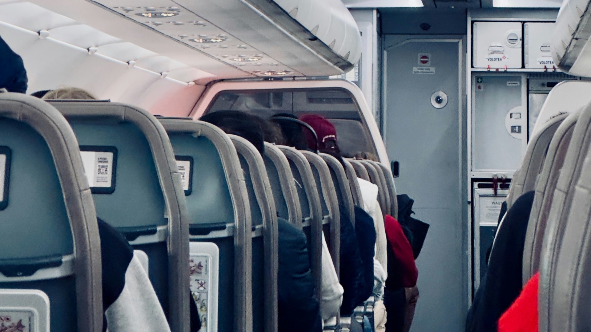 Inside of an airplane cabin with exit signs.