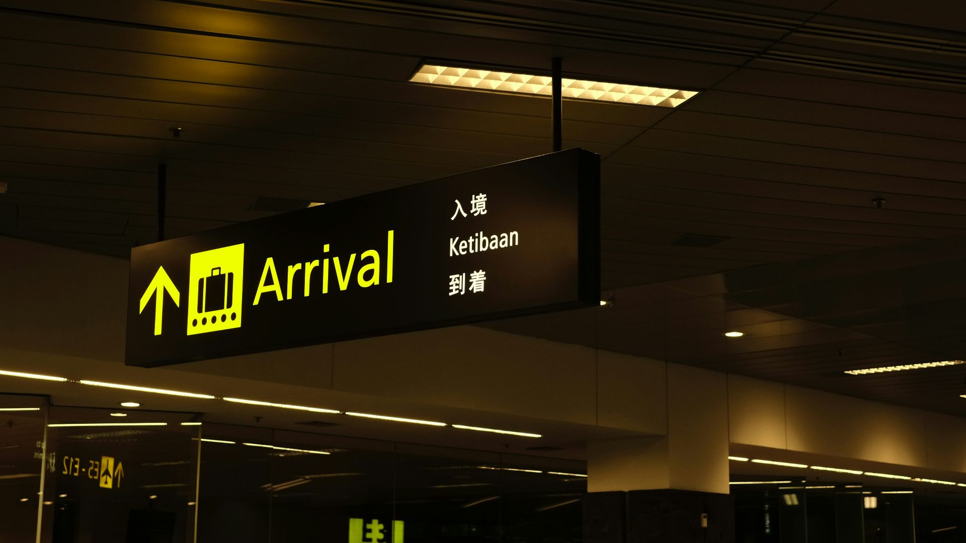 a black and yellow sign hanging from a ceiling