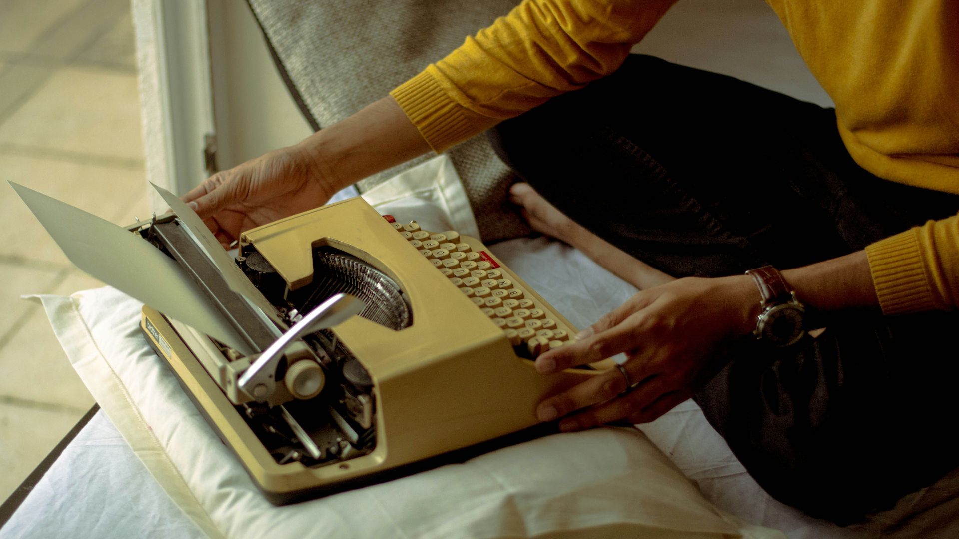person using yellow typewriter