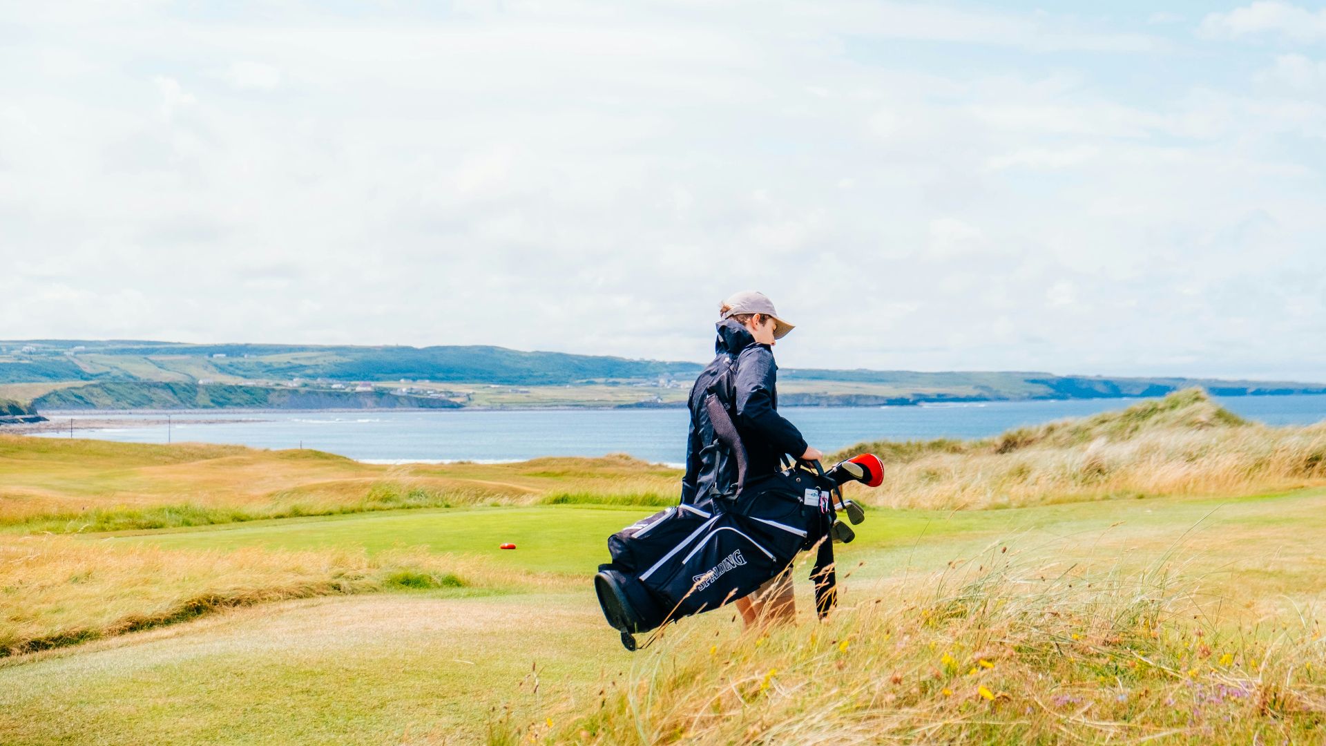 a man walking across a lush green field