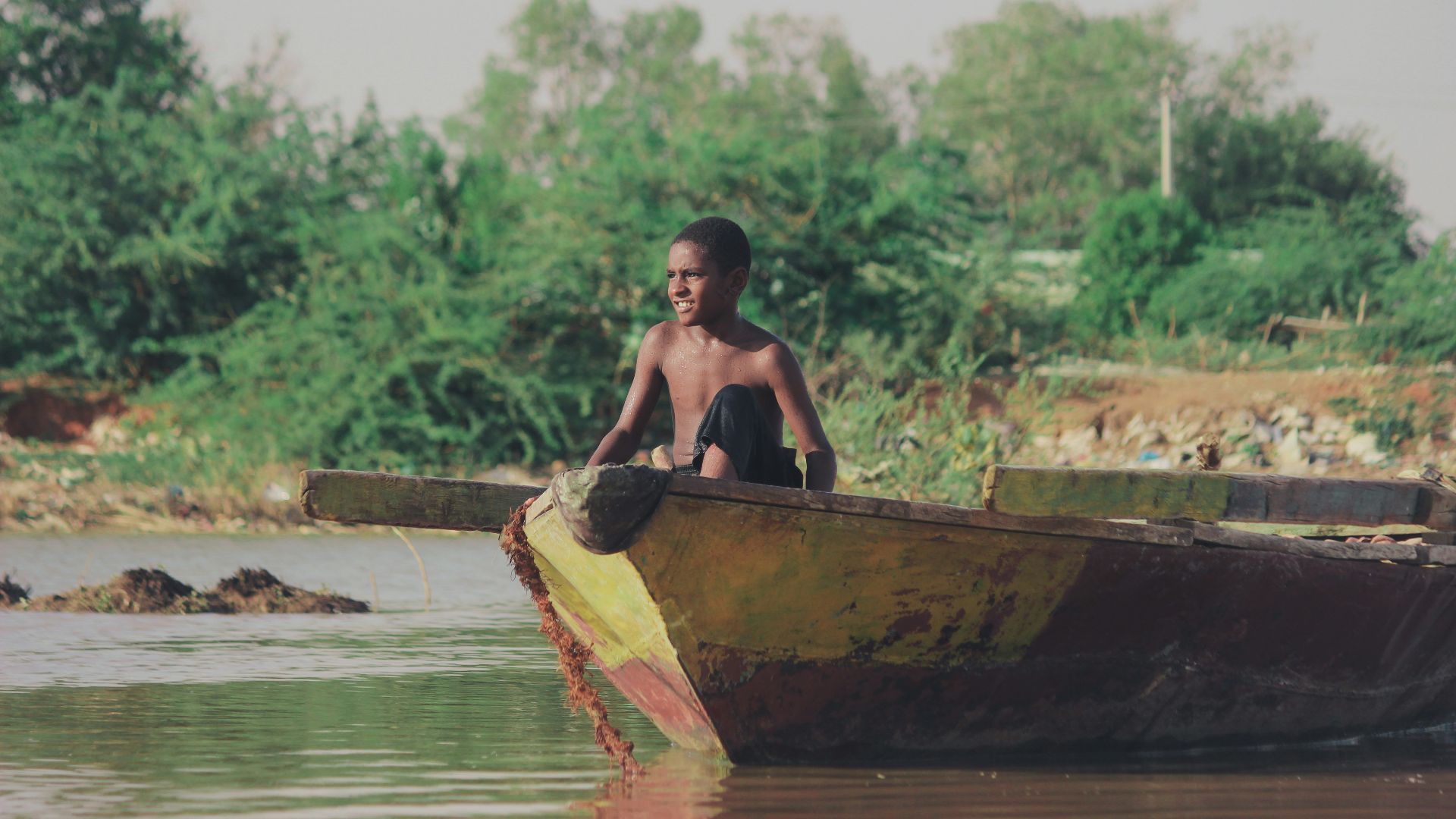 man in brown boat on river during daytime