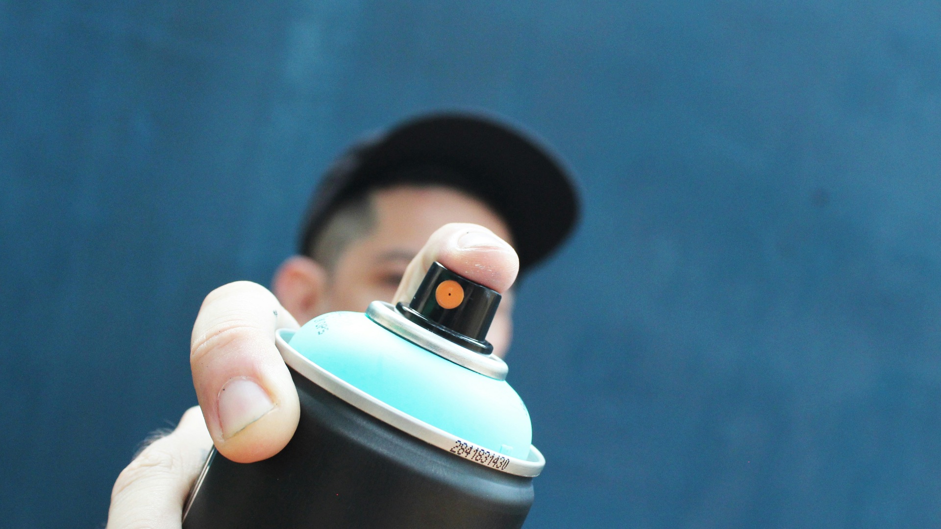 a man holding a black and blue spray can