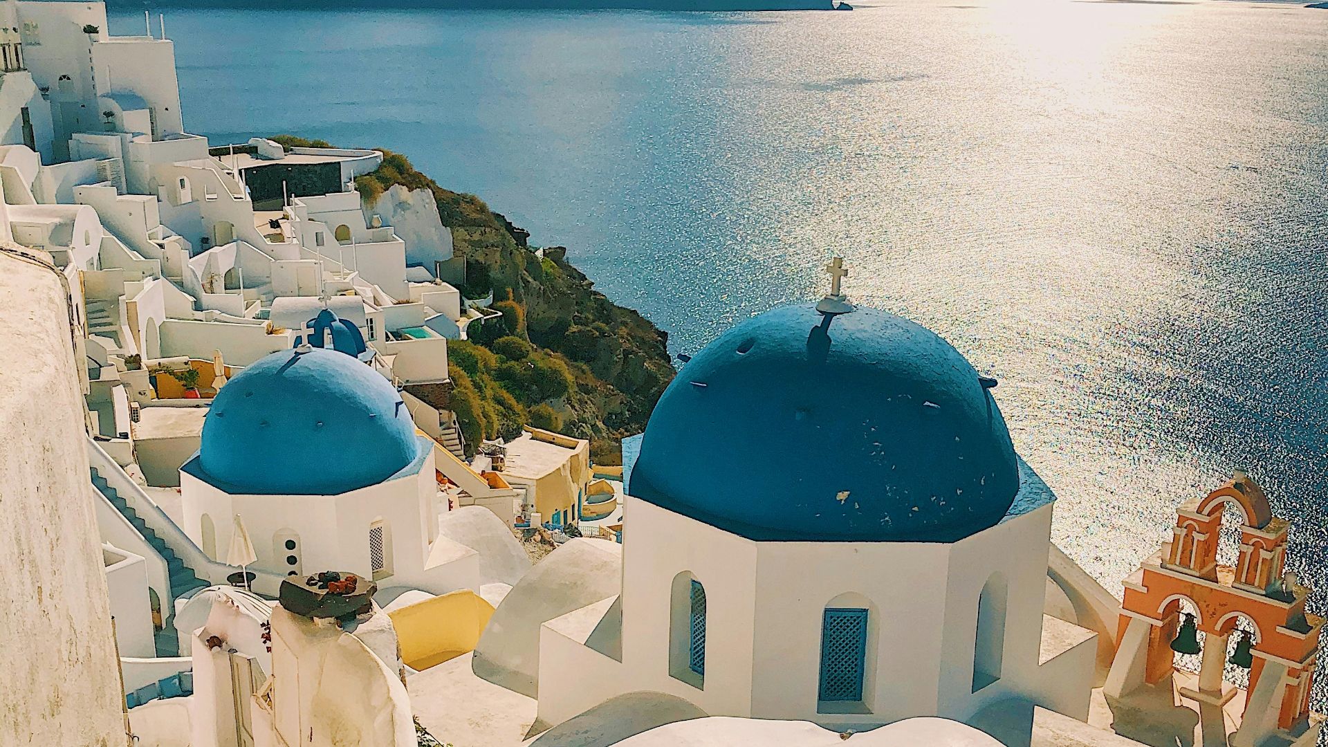 white and blue concrete building near body of water during daytime